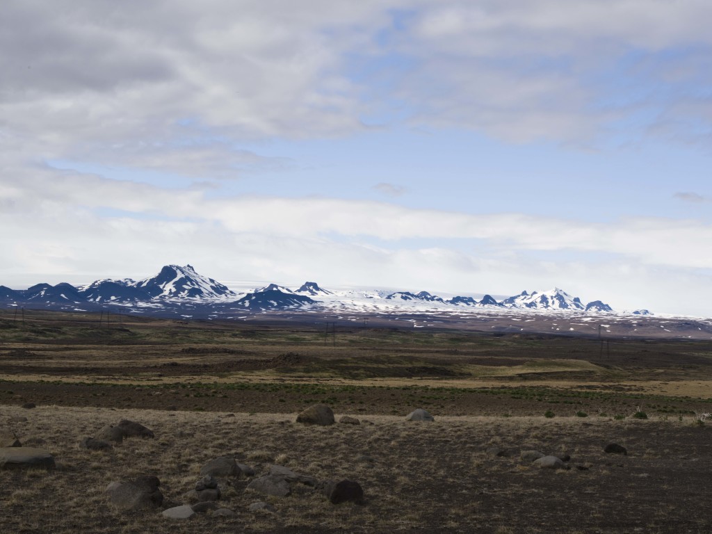 The white slope you can barely see behind the peaks is an ice-field. Not clouds.